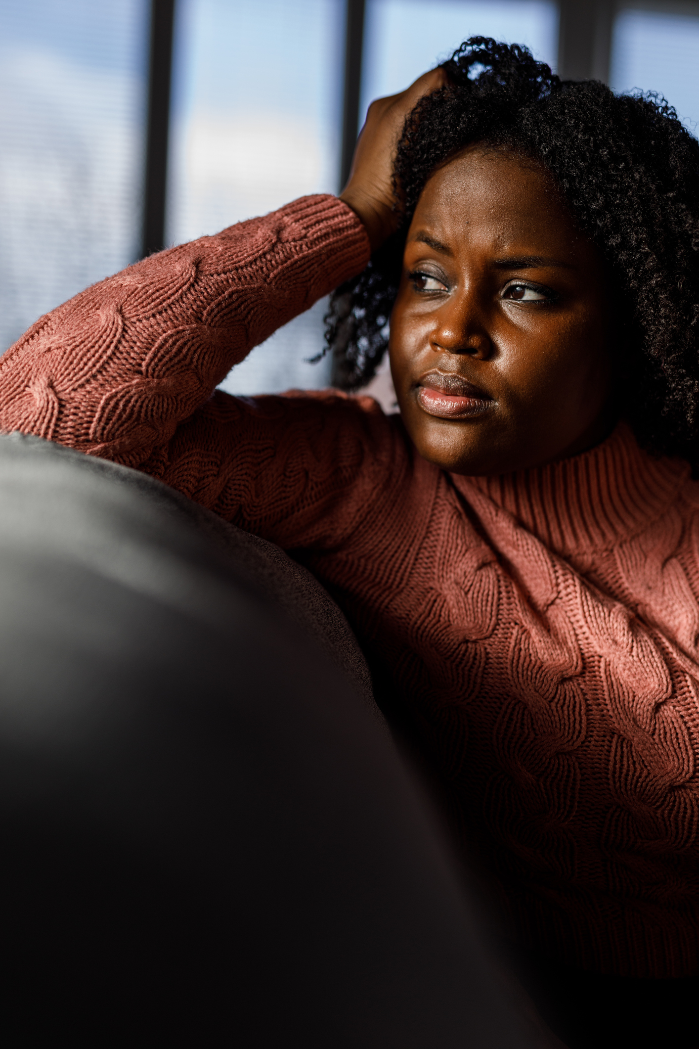 Anxious young woman - Delusional Disorder Anxious young woman sitting on the sofa, looking away, worrying - delusional disorder