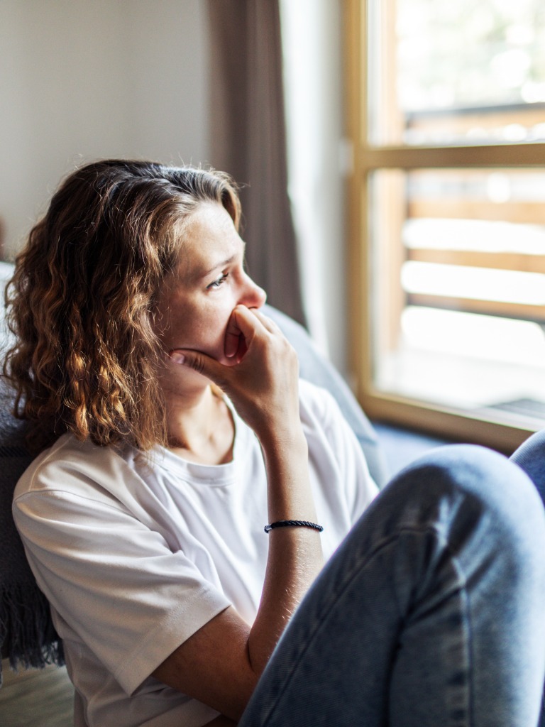 woman sitting looking worried - delusional disorder woman sitting looking worried - delusional disorder