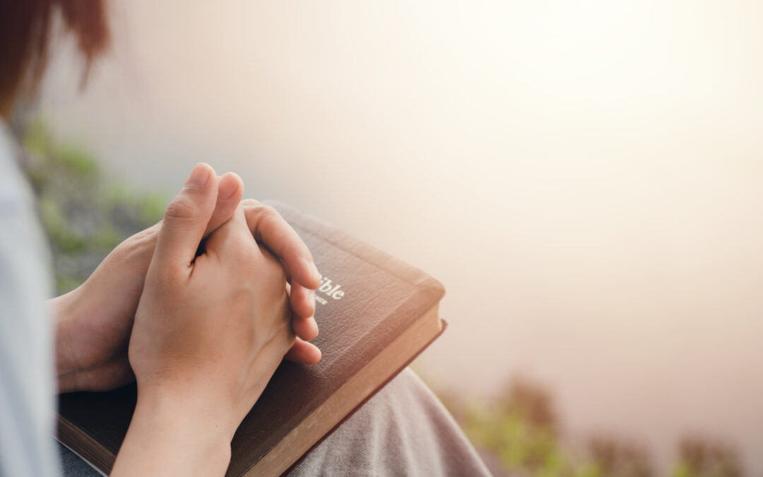 A girl praying, with a Bible, as an illustration of faith integrated treatment