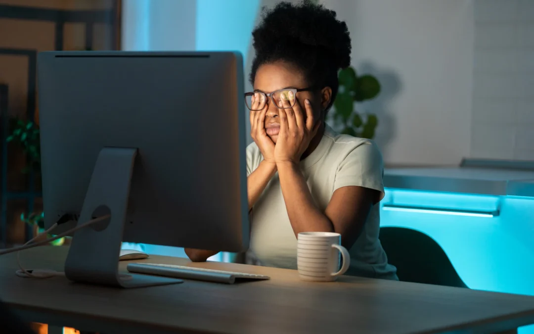 Adult sitting at a cluttered desk surrounded by unfinished tasks