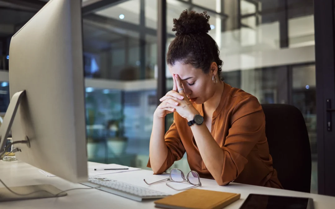 Woman working late at her desk looking composed but tense, a common presentation of high functioning anxiety.