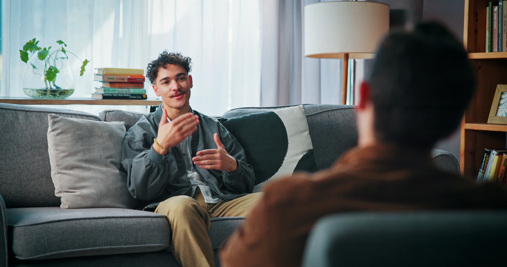 Two adults talking together on a sofa in a living room
