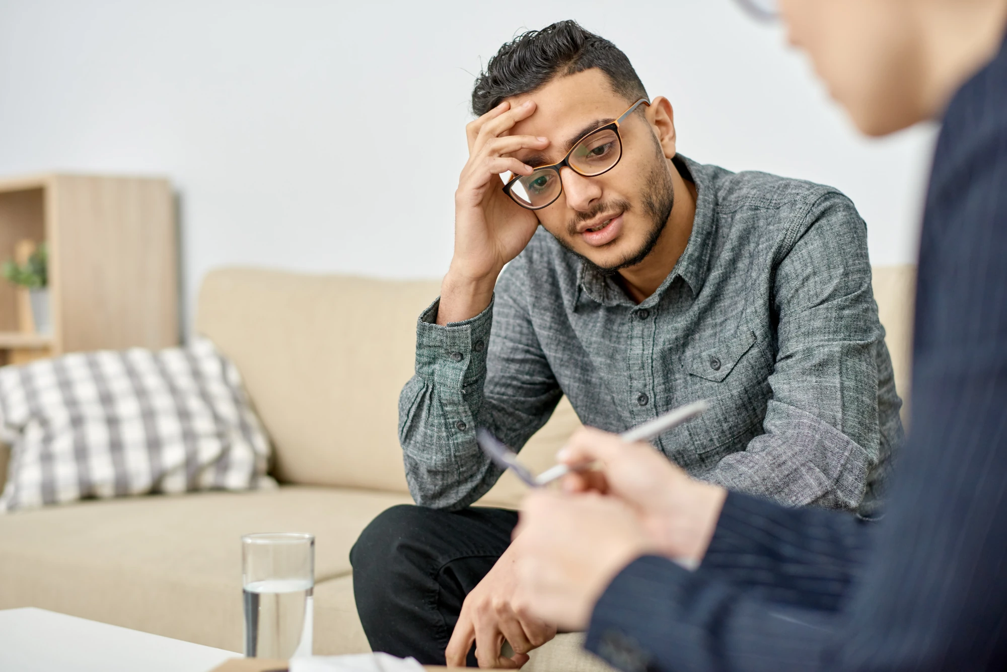 Two adults in a quiet conversation at home, representing family support for a physician considering mental health treatment.