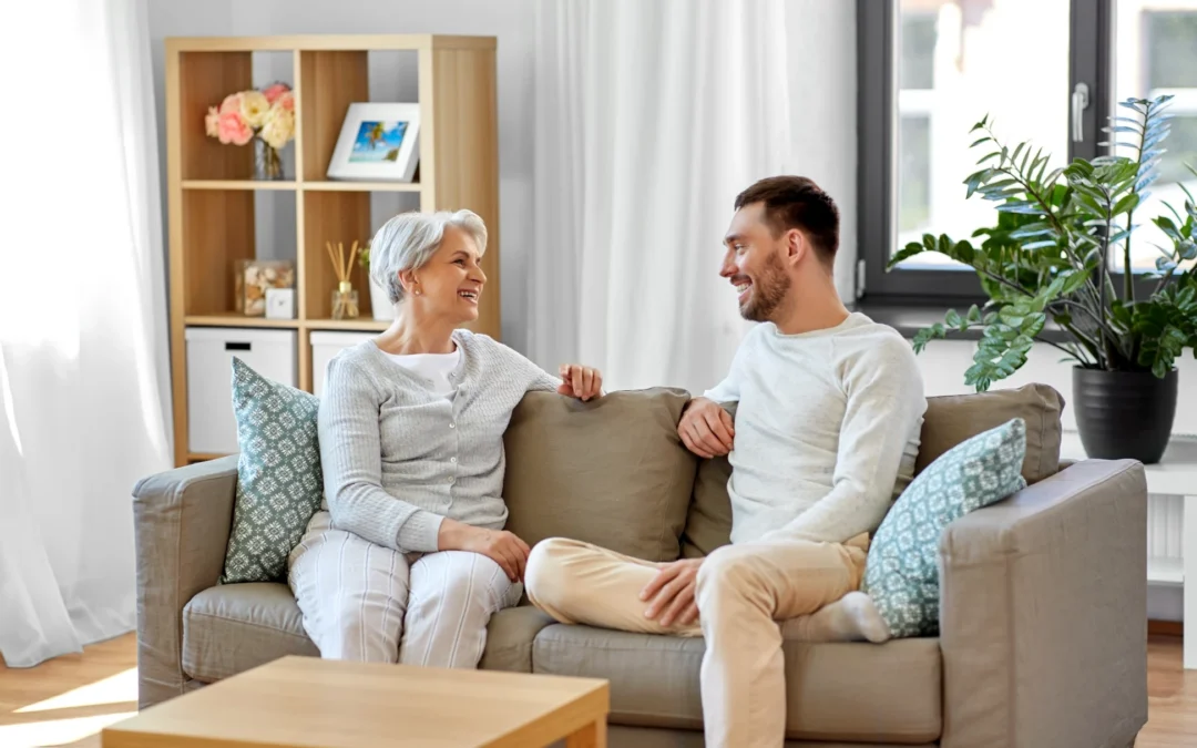 An older woman and a young man sitting on a couch at home, having a serious conversation