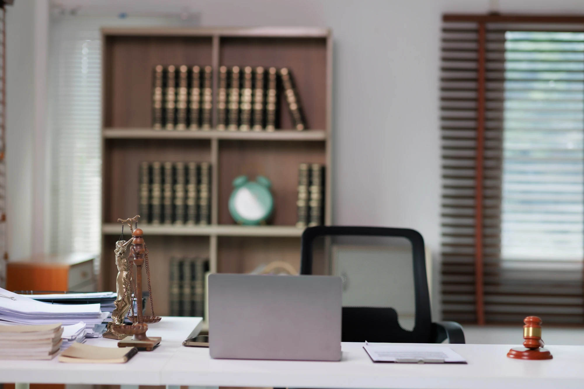 A quiet law office with shelves of legal books, a wooden desk, and a window letting in natural light